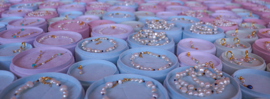 Close up af perlesmykker med armbånd og øreringe i smykkeæsker.