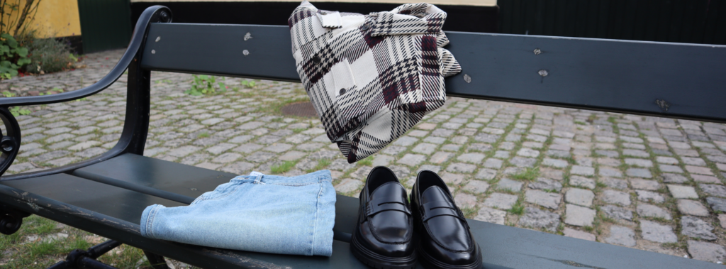 Sko, bukser og skjorter på en bænk