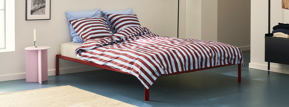 En send med sengetøj i røde og lyseblå striber.