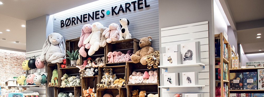 Et billede af en butik – en stor hylde med bamser til børn