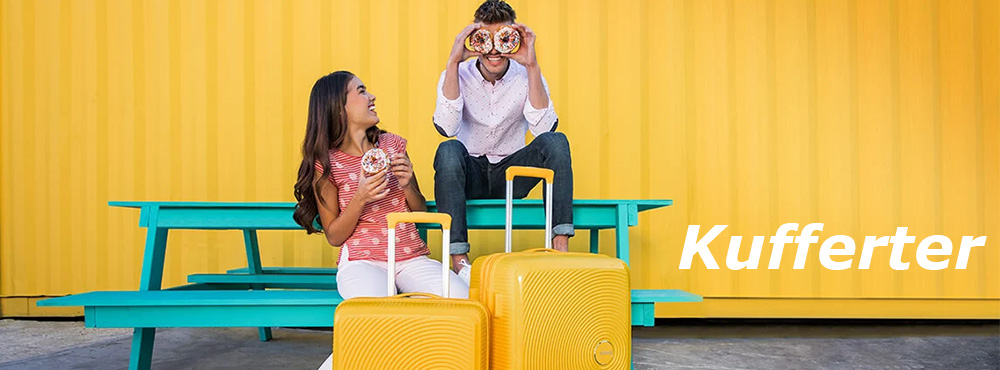 En mand og en kvinde sidder på en bænk, de har hver deres gule kuffert foran sig. 