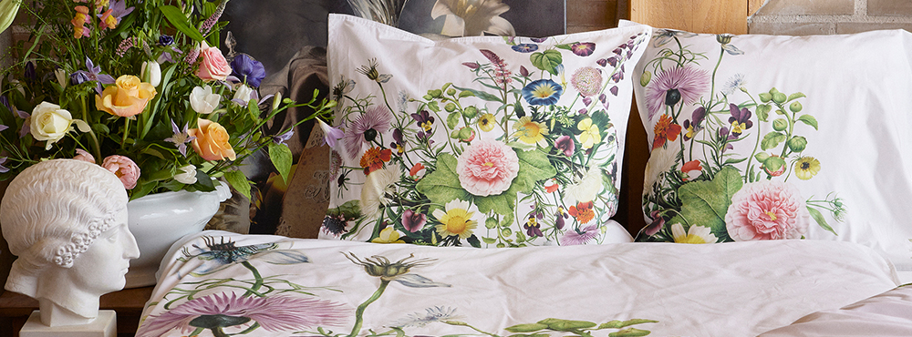En seng med puder med blomster. Produkter fra Koustrup & Co.