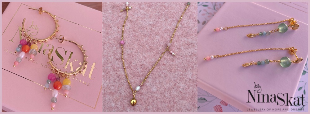To sæt øreringe med farverige perler på og en guldhalskæde i midten af billedet.